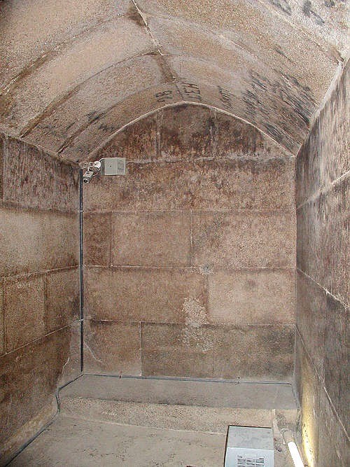 The Burial Chamber of Menkaure. It is lined with granite and the roof beams have been cut away to gi